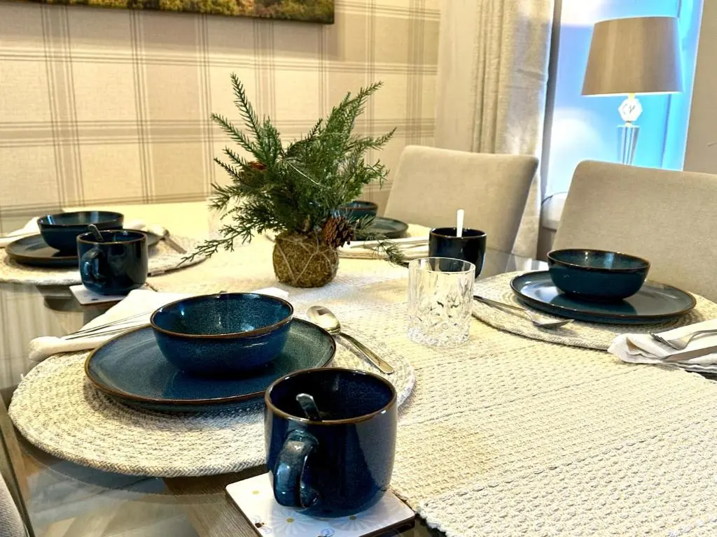 a table with blue bowls and plates on it at Beechtree Cottage, Ardle Family Room, Kirkmichael in Kirkmichael