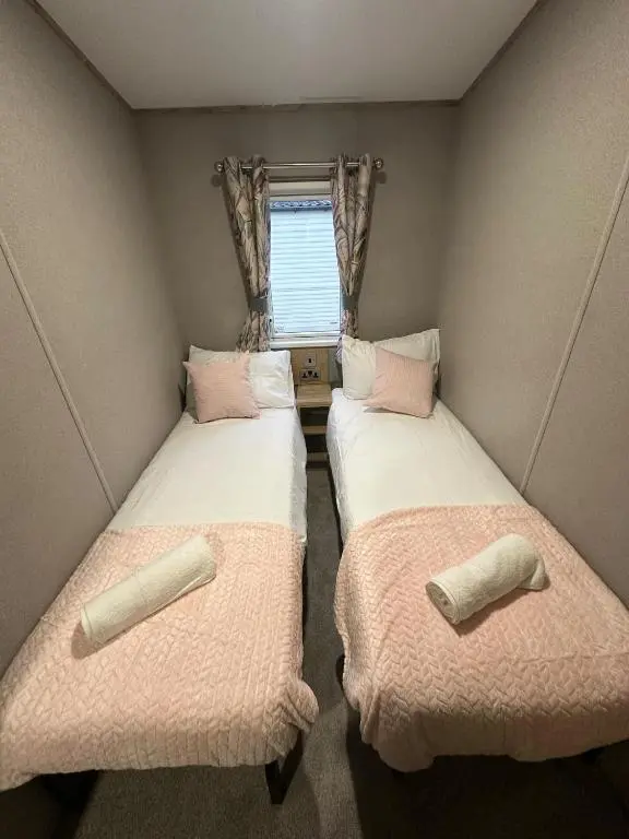 two beds in a small room with a window at Clearwater View - Stunning sea views from large deck in Burghead
