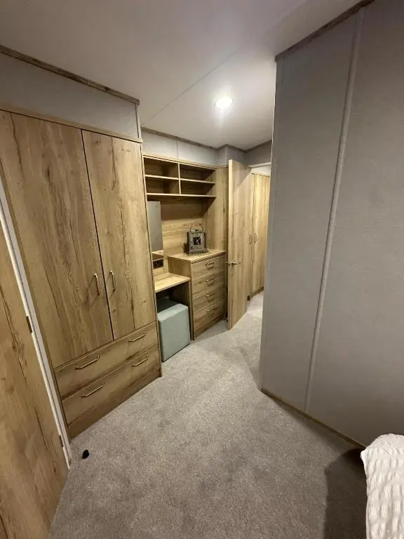 a room with a kitchen with wooden cabinets at Clearwater View - Stunning sea views from large deck in Burghead
