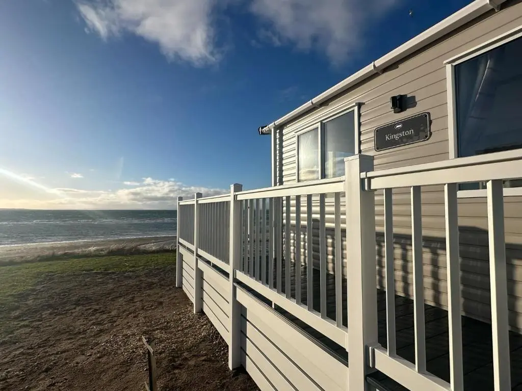 a house on the beach with a fence at Clearwater View - Stunning sea views from large deck in Burghead
