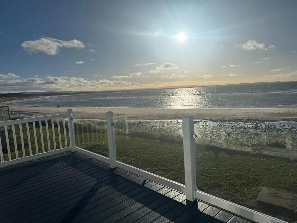 a view of the beach from the deck of a house at Clearwater View - Stunning sea views from large deck in Burghead