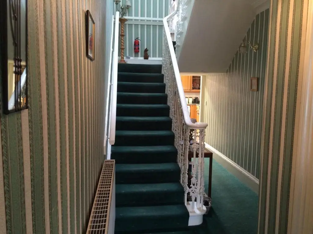 a stairway with green carpet and green stairs at Ardgarry Holiday House in Inverness