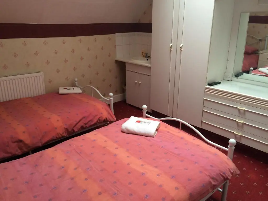 a bedroom with a red bed and a mirror at Ardgarry Holiday House in Inverness