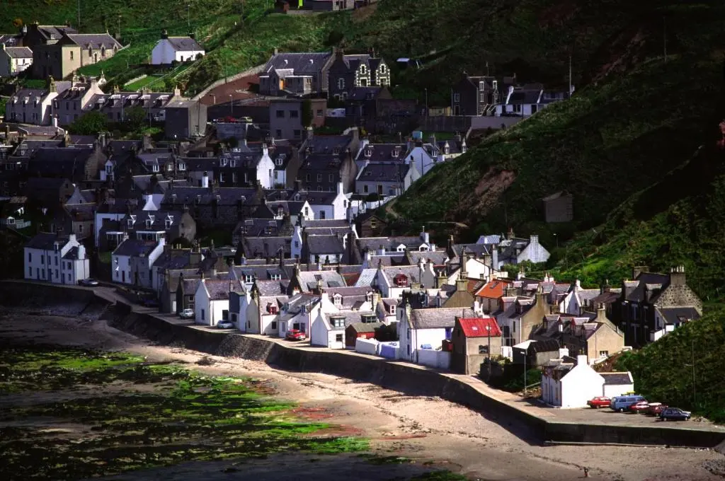a group of houses on the side of a hill at Bright comfy home, sea views and big skies in Banff