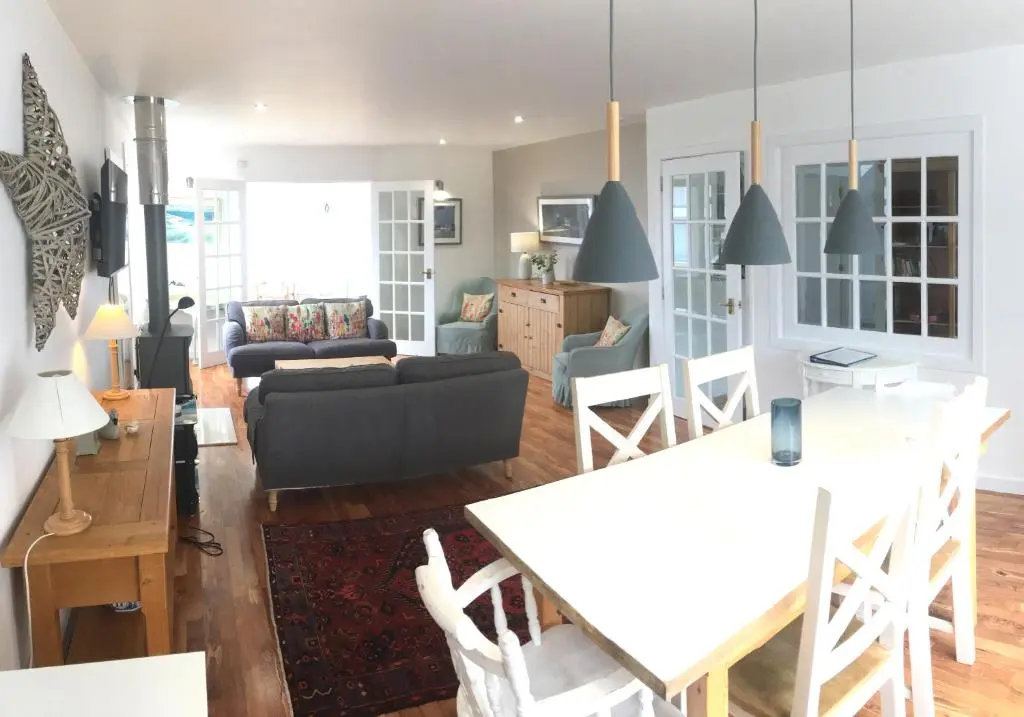a living room with a couch and a table at Bright comfy home, sea views and big skies in Banff
