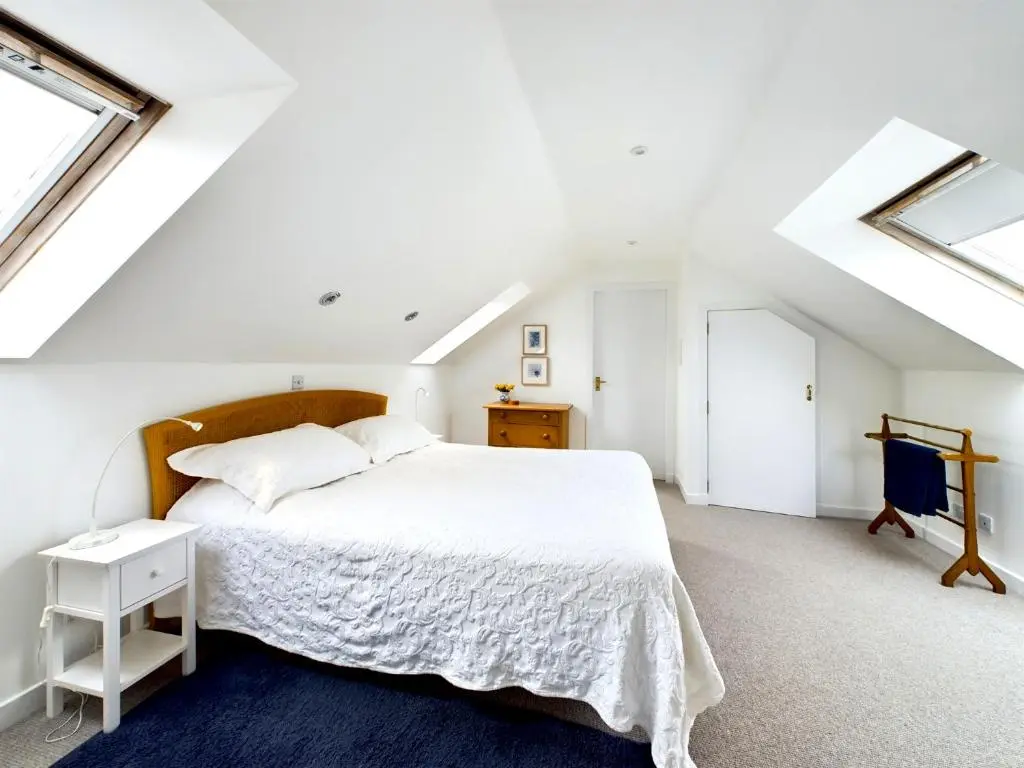 a white bedroom with a large bed and windows at Bright comfy home, sea views and big skies in Banff