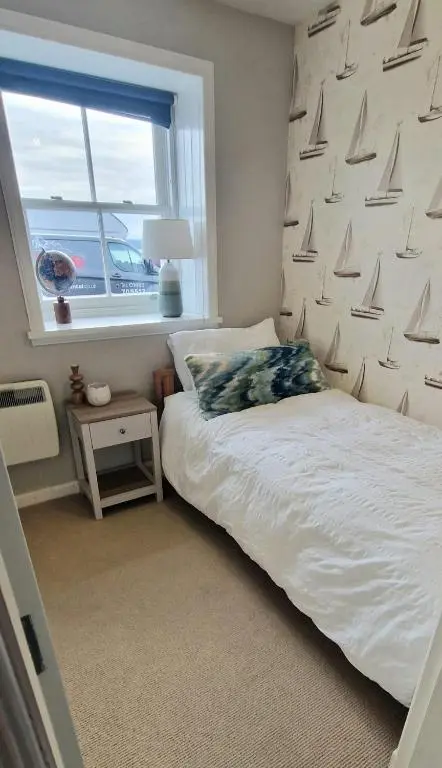 a bedroom with a bed and a window with sails on the wall at North Coast Property - Avoch Beach House - Luxury house with sea views in Avoch