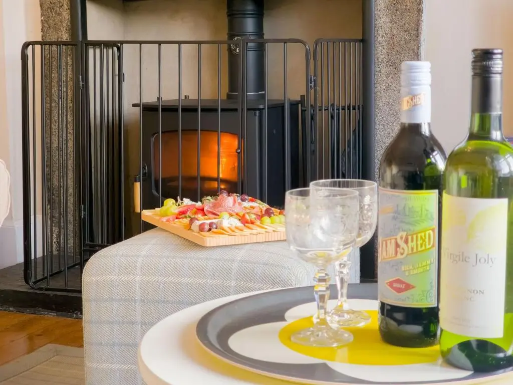 a table with two glasses and a bottle of wine at Schoolhouse in Laggan
