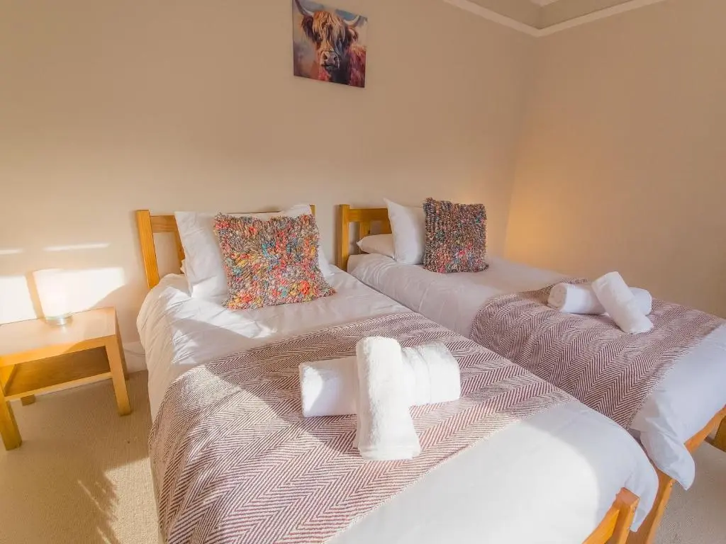 two beds sitting next to each other in a room at Schoolhouse in Laggan
