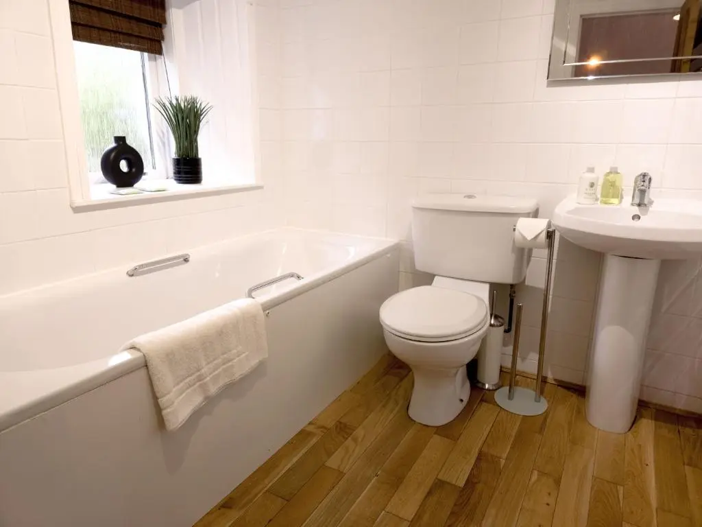 a white bathroom with a toilet and a sink at Schoolhouse in Laggan