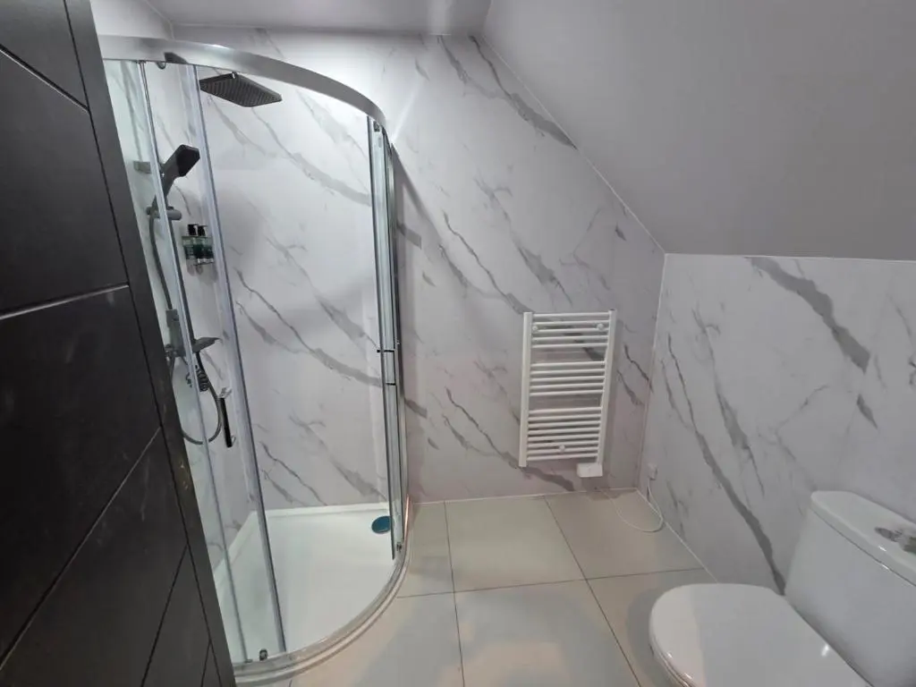 a bathroom with a shower and a toilet and a sink at Woodside House in Crook of Alves