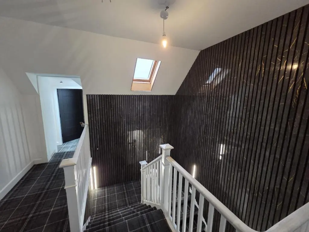 a staircase with a black tile wall and a window at Woodside House in Crook of Alves