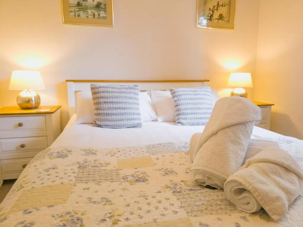 a bedroom with a bed with towels on it at Taigh Mathair Taigh Mathair in Nethy Bridge