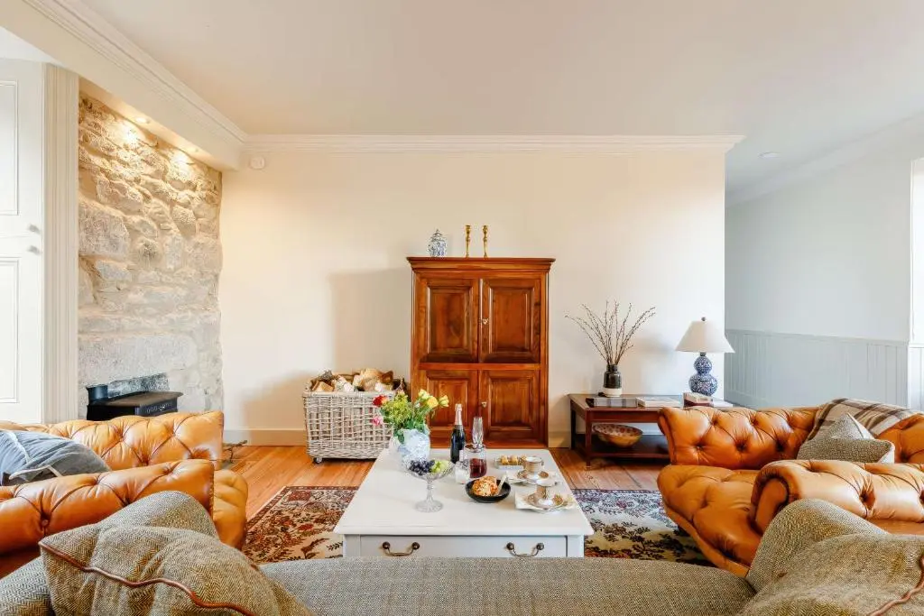 a living room with leather couches and a table at Burnhervie House in Inverurie