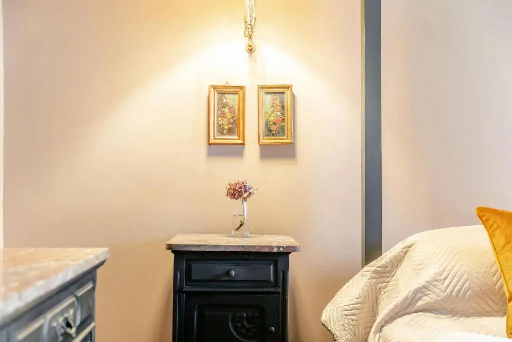 a bedroom with a bed and a table with flowers on it at Burnhervie House in Inverurie