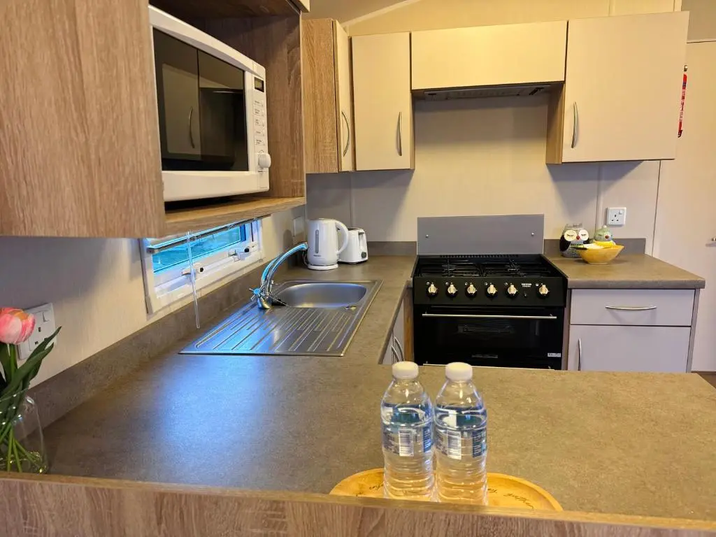 a kitchen with two bottles of water on a counter at Little Cha-Am Caravan Hire at Silver Sands in Lossiemouth