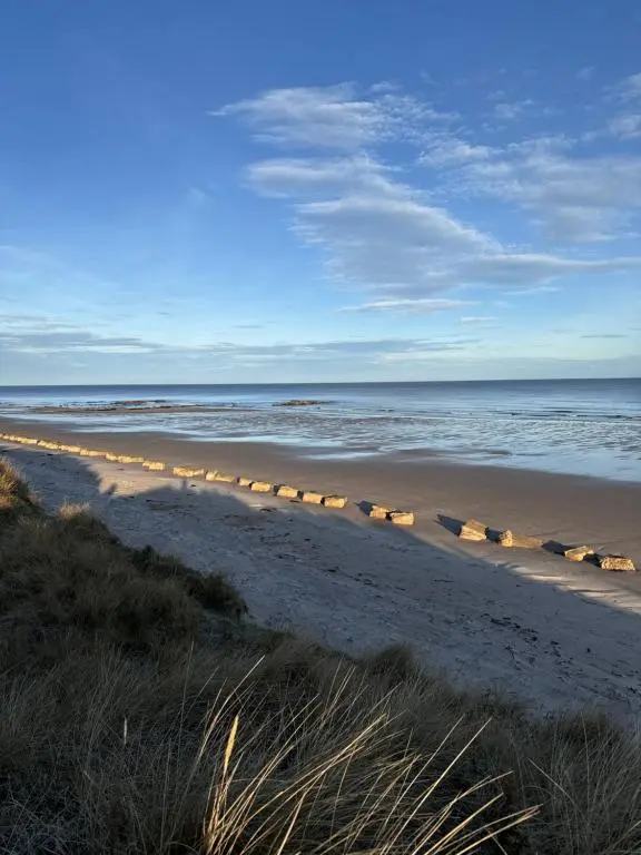 a beach with a row of lights on the sand at Little Cha-Am Caravan Hire at Silver Sands in Lossiemouth