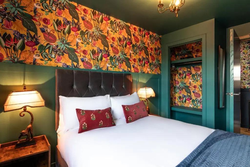 a bedroom with a bed and a floral wall at Ness in the City in Inverness