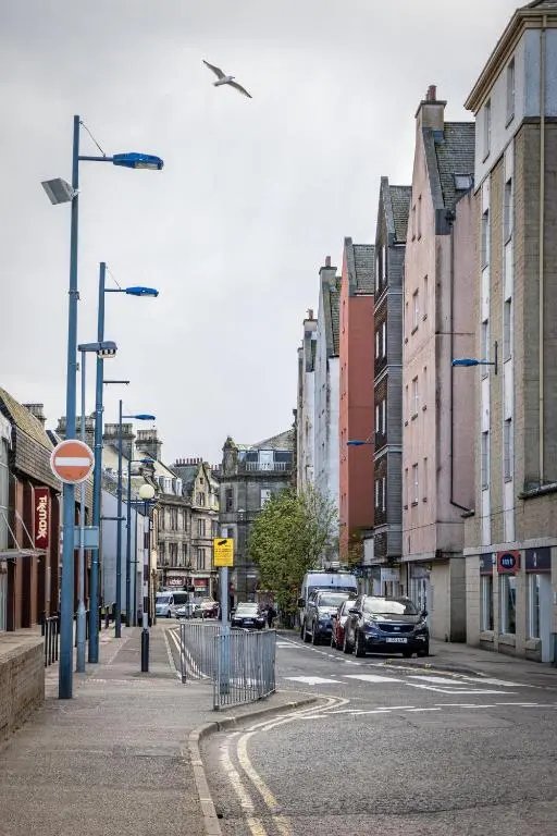 a city street with cars parked on the street at Ness in the City in Inverness