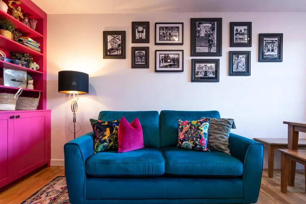a blue couch in a living room with pictures on the wall at Ness in the City in Inverness