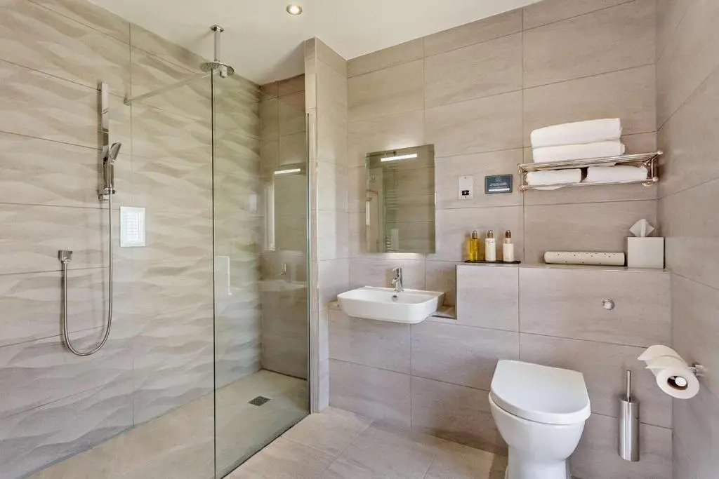 a bathroom with a shower and a toilet and a sink at Glenmore Lodge in Skye of Curr