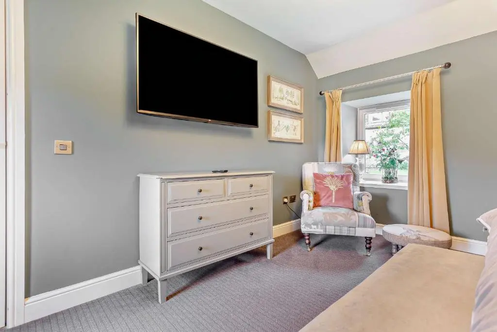 a bedroom with a dresser and a tv on the wall at Cairngorm Cottage in Skye of Curr