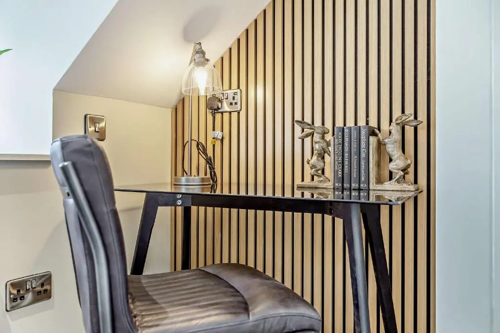 a table and a chair in a room with a wall at Cairngorm Cottage in Skye of Curr
