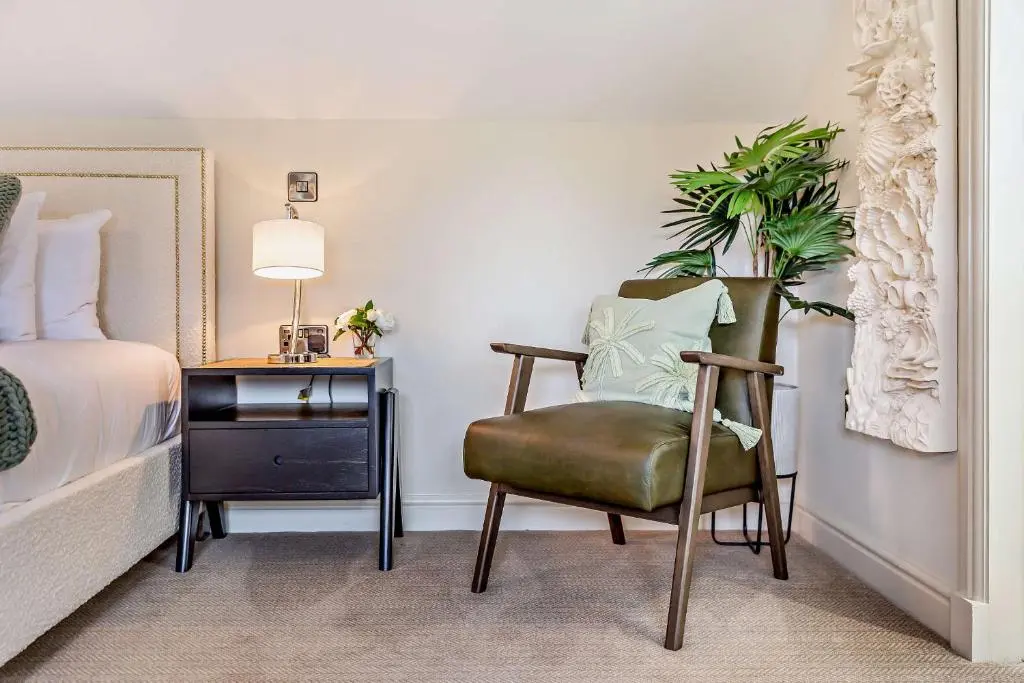 a bedroom with a chair and a desk with a plant at Cairngorm Cottage in Skye of Curr