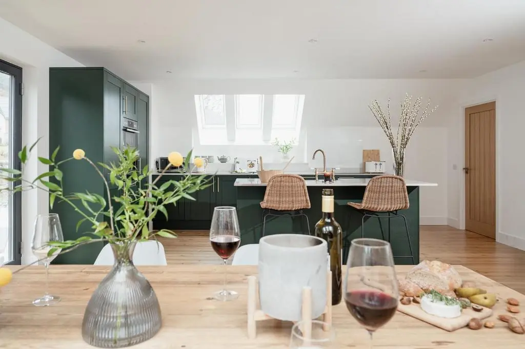 a kitchen with a table with two glasses of wine at Osprey's Nest - Seasgair Lodges in Broomhill Station