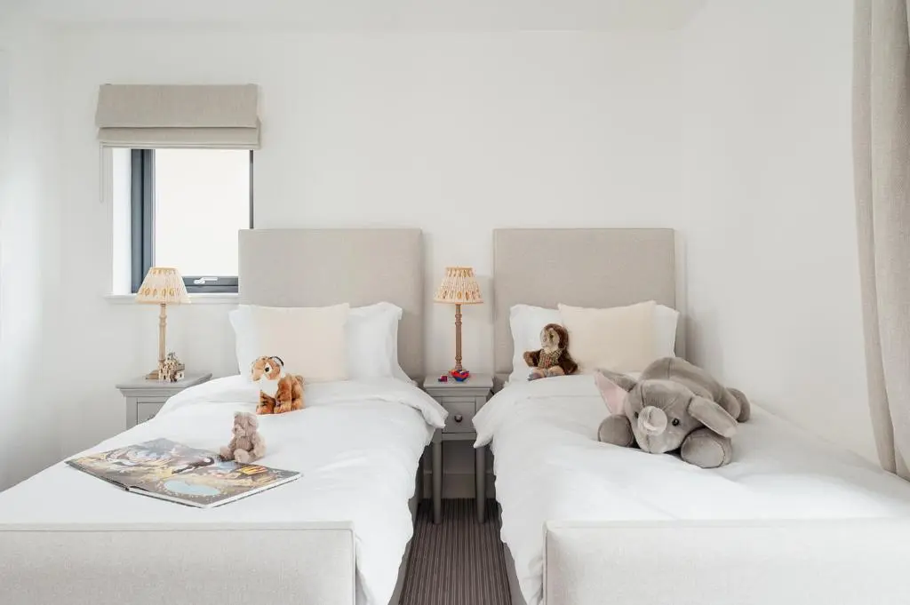 two beds with stuffed animals on them in a bedroom at Osprey's Nest - Seasgair Lodges in Broomhill Station