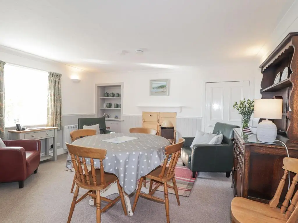 a living room with a table and chairs at Fuchsia Cottage in Fortrose