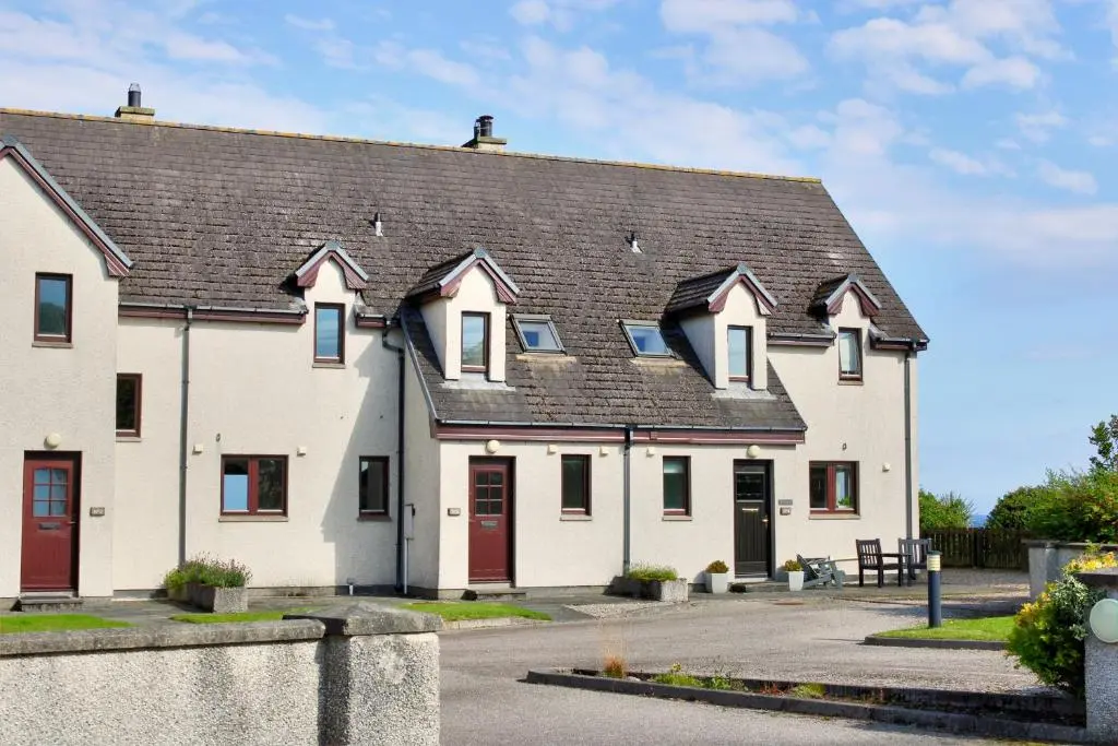 a large white house with a black roof at 2 Links View, Brora in Brora