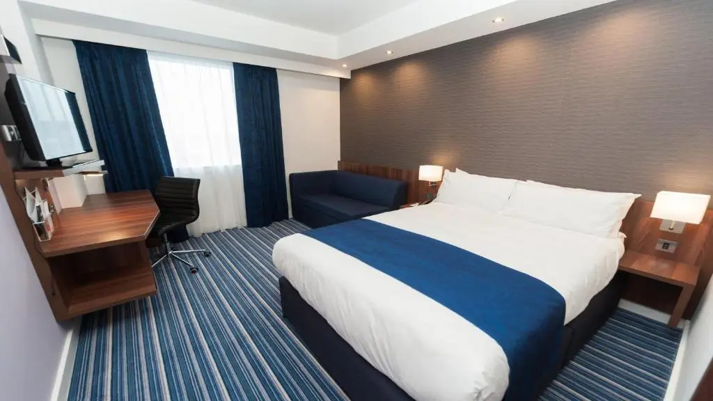 a hotel room with a large bed and a desk at Holiday Inn Express Aberdeen Airport by IHG in Dyce