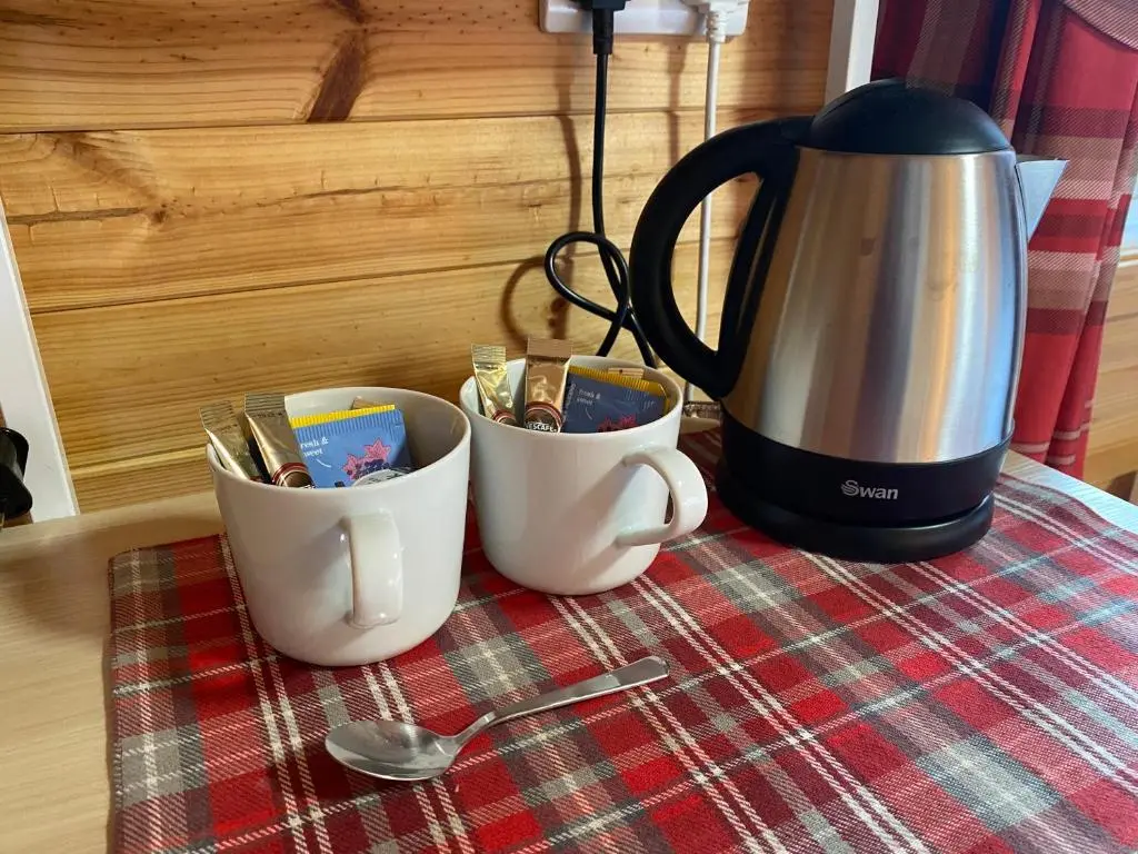 a coffee pot and two cups on a table at An Cabar - Cabin in Aviemore, Cairngorms NP in Aviemore