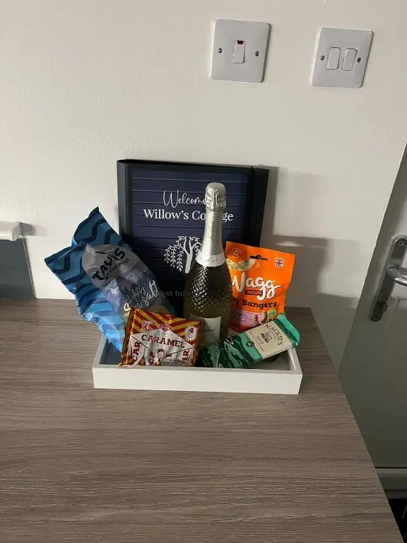 a gift basket with a bottle of wine and chips at Willow's Cottage in Auldearn
