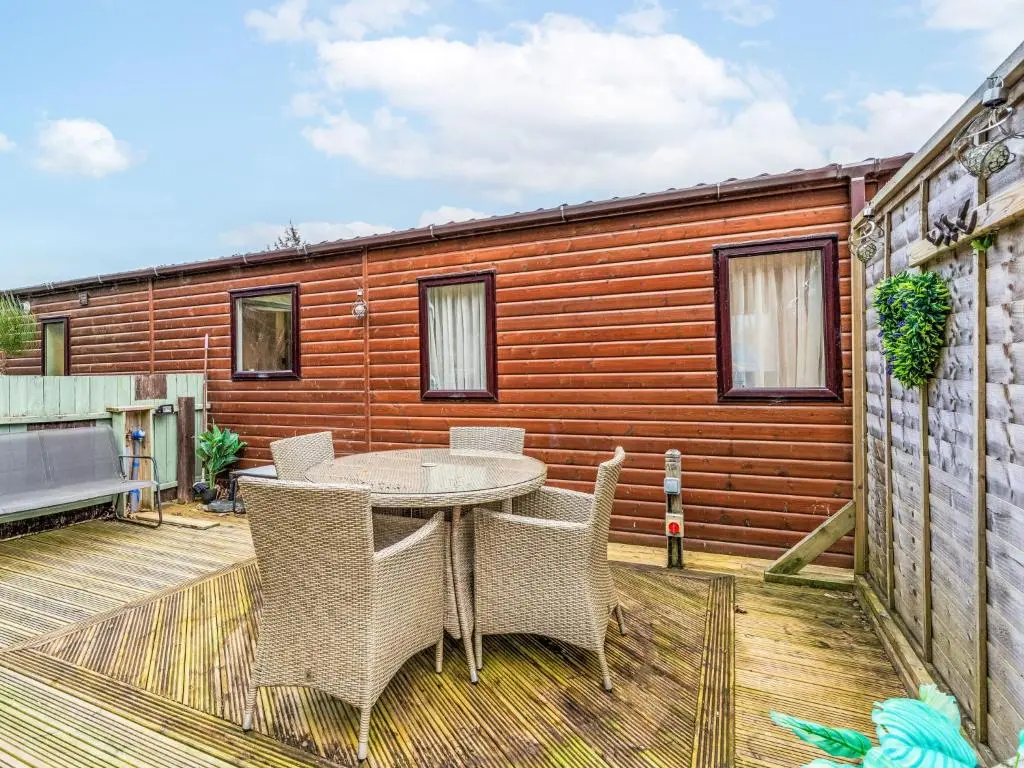 a patio with a table and chairs on a deck at Chalet Cairn View by Interhome in Aviemore