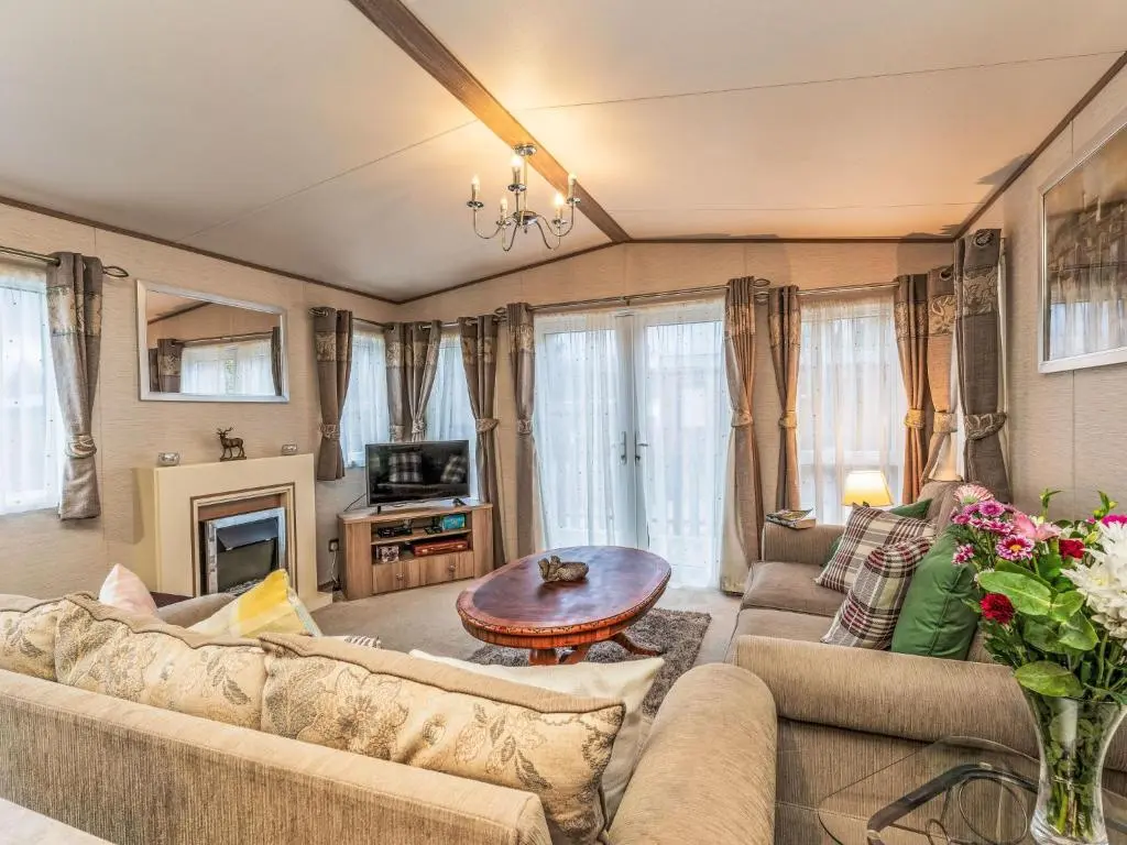 a living room with two couches and a table at Chalet Cairn View by Interhome in Aviemore