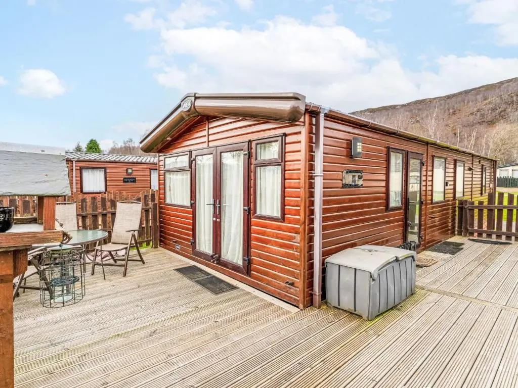 a cabin on a deck with a table and chairs at Chalet Monarch by Interhome in Aviemore