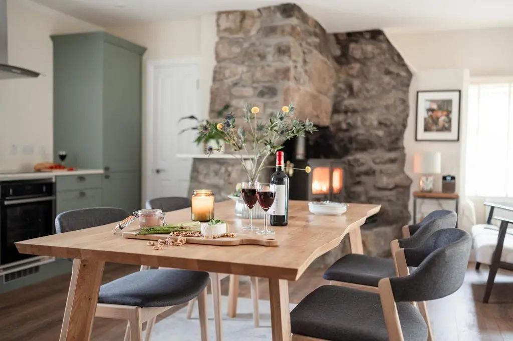 a dining room table with wine glasses and candles at The Old Smithy - Seasgair Lodges in Nethy Bridge