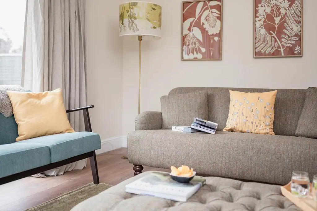 a living room with a couch and a chair at The Old Smithy - Seasgair Lodges in Nethy Bridge