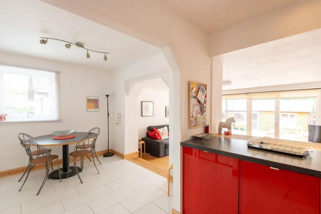 a kitchen and dining room with red cabinets and a table at 4guests-2br-privategarden-freeparking in Aviemore