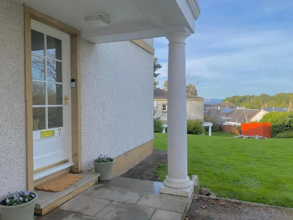 a porch of a house with a white door at Warm, stylish 2-bed in Crown, Inverness in Inverness