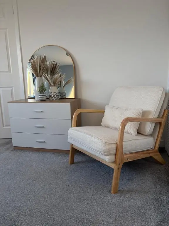a room with a chair and a dresser with a mirror at Number Forty Two, Portsoy - A 3 bedroom cottage with sea views in Portsoy