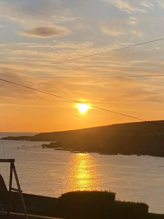 a sunset over a body of water with the sun setting at Number Forty Two, Portsoy - A 3 bedroom cottage with sea views in Portsoy