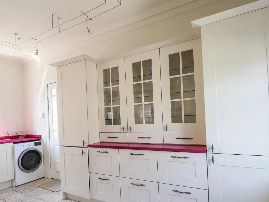 a kitchen with white cabinets and a washing machine at Mary Ann Villa in Inverness