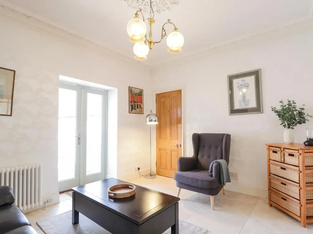 a living room with a chair and a table at Mary Ann Villa in Inverness