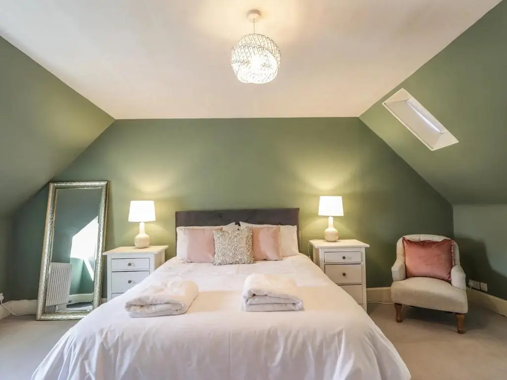 a bedroom with a large bed and a mirror at Mary Ann Villa in Inverness