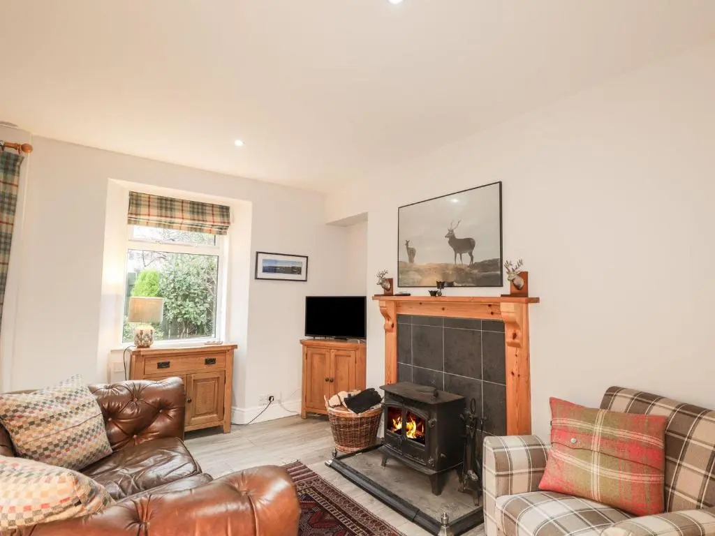 a living room with a couch and a fireplace at Wendy's Place in Inverness