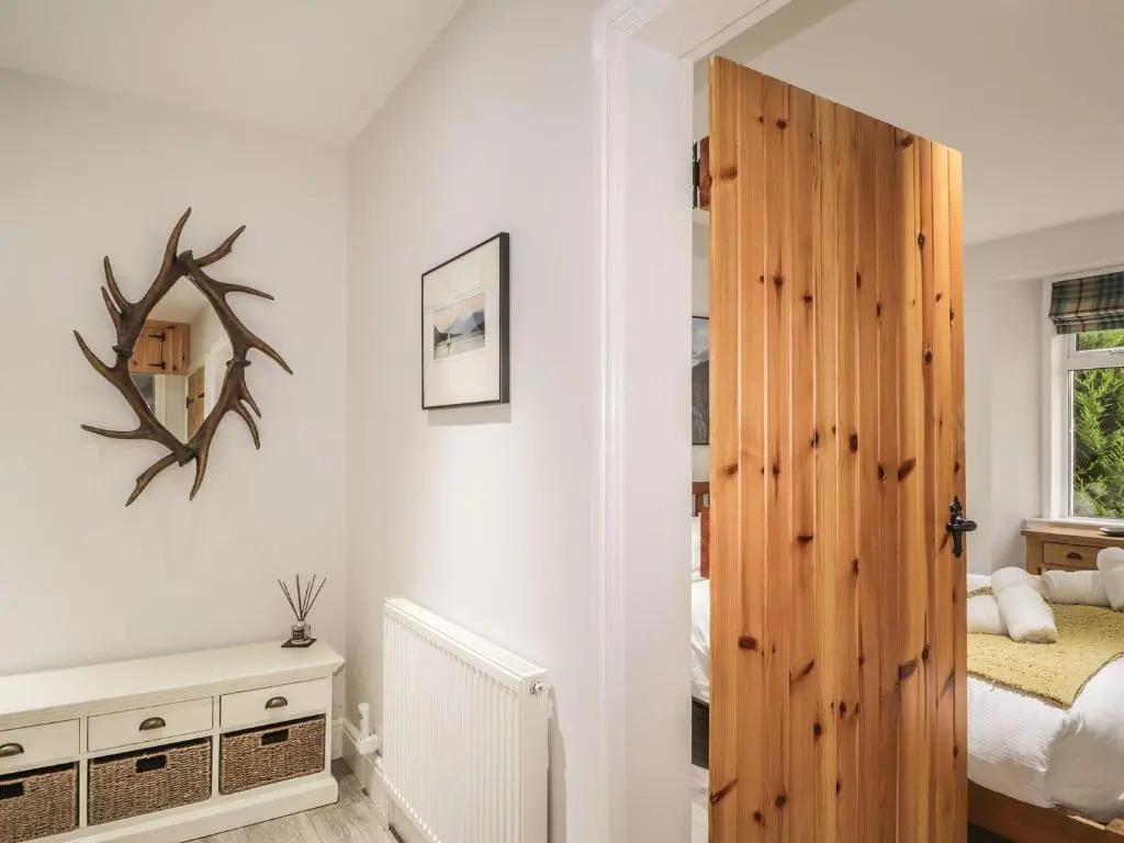 a bedroom with a wooden door and a bed at Wendy's Place in Inverness