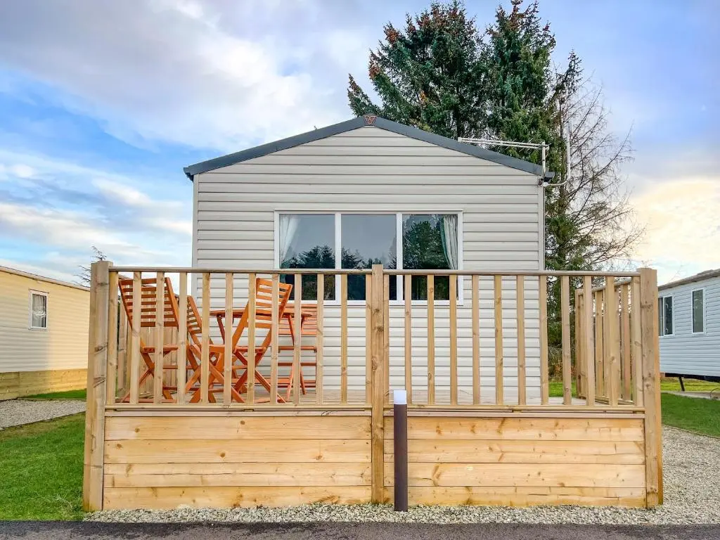 a wooden fence with two chairs and a house at The Kestrel - Ukc6920 in Forres